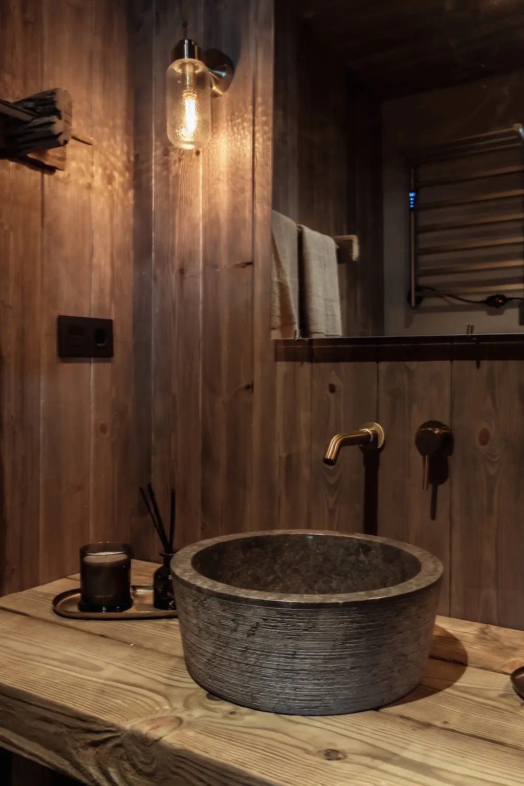 Baño de madera con lavabo de piedra