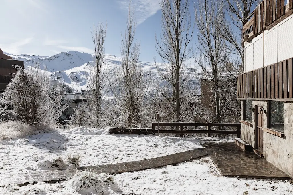 La Cabane con el jardín nevado y la sierra al fondo