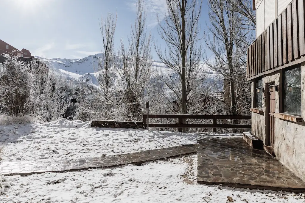 Jardín nevado con vistas a la montaña
